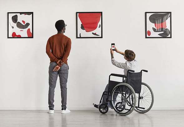 Person in a wheelchair visiting an art gallery